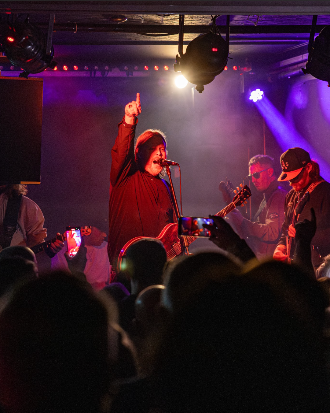 Band performing on stage with audience in foreground